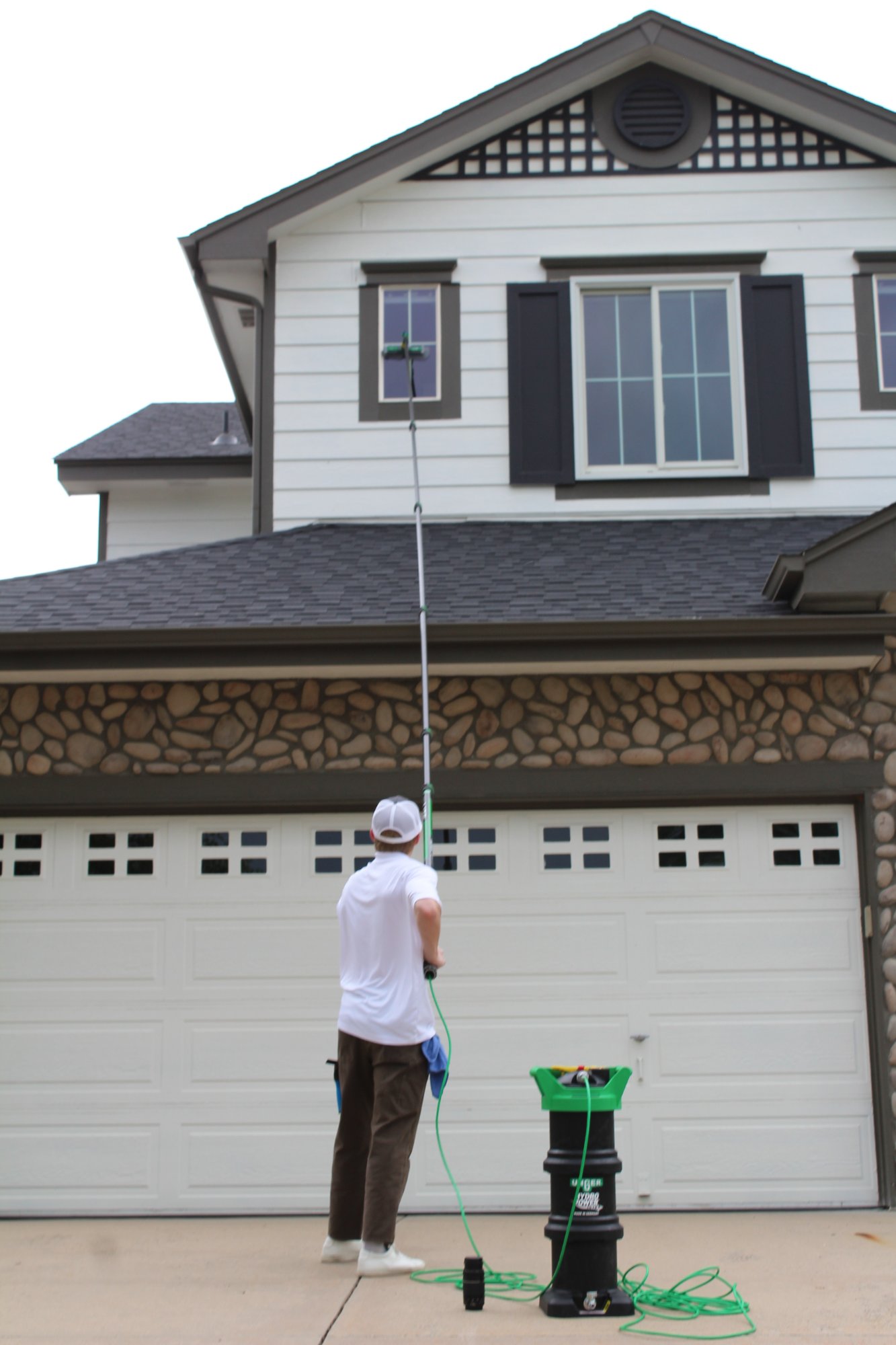 Cleaning second-story windows with water-fed pole
